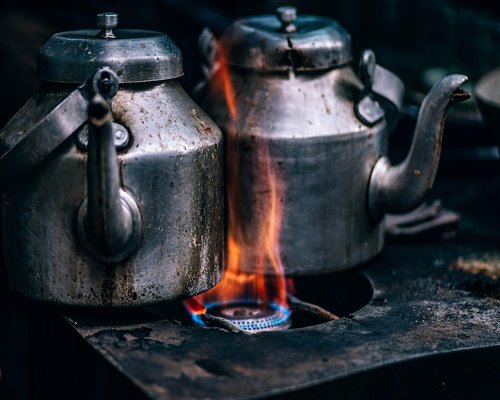 Finely crushed premium black tea leaves steeping inside a traditional metal kettle