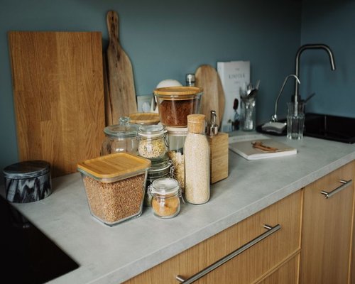 A perfectly pristine home kitchen displaying covered glass storage jars and dry preparation cutting boards